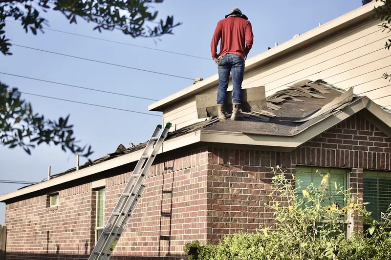 Professional roofer working on a residential roof in Learn Settlement